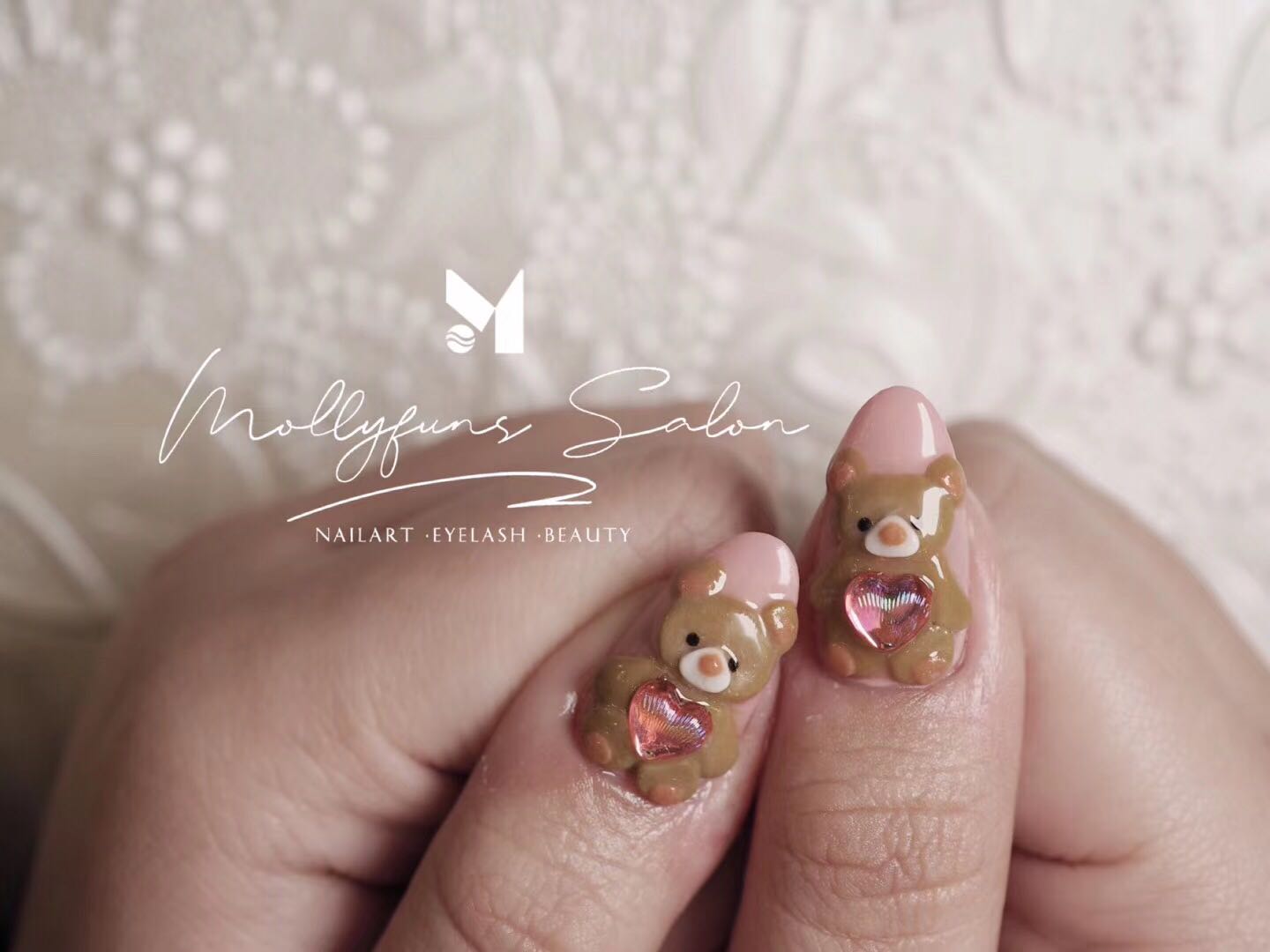 3D sculpted teddy-bear charms with pink heart gems on almond nails